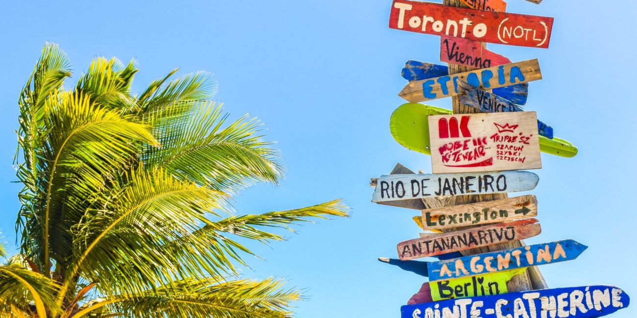 tabliczki z różnymi kierunkami podróży na plaży Long Bay Beach, na wyspach Turks i Caicos Islands