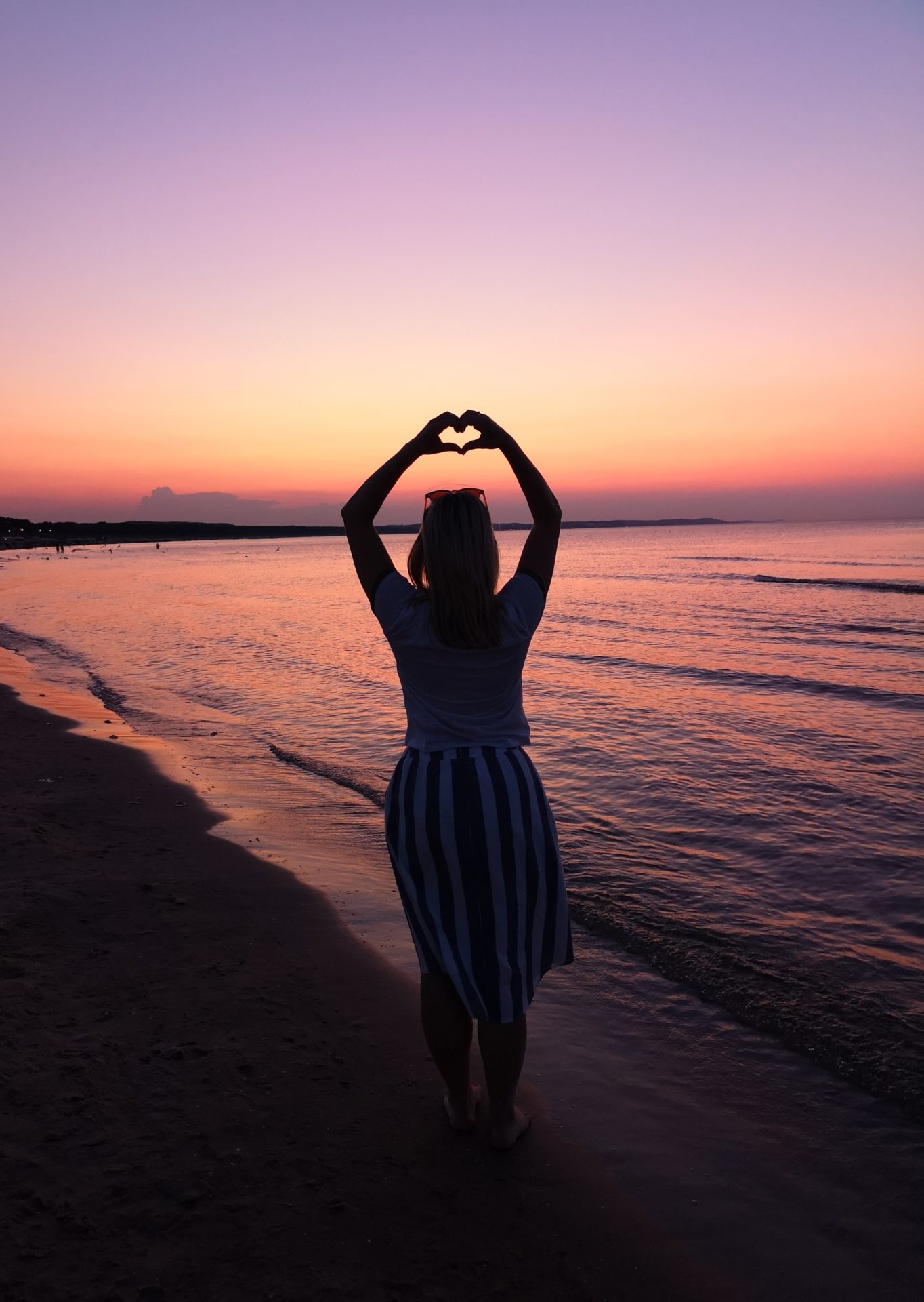 Fotografia dziewczyny na plaży o zachodzie słońca
