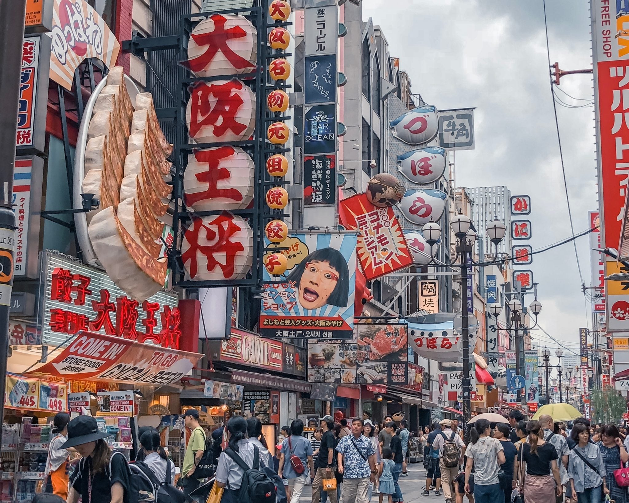 Główna ulica Osaki z neonami i kiczowatymi symbolami, plastikowy krab i pierogi gyoza, tłum spacerujący ulicą