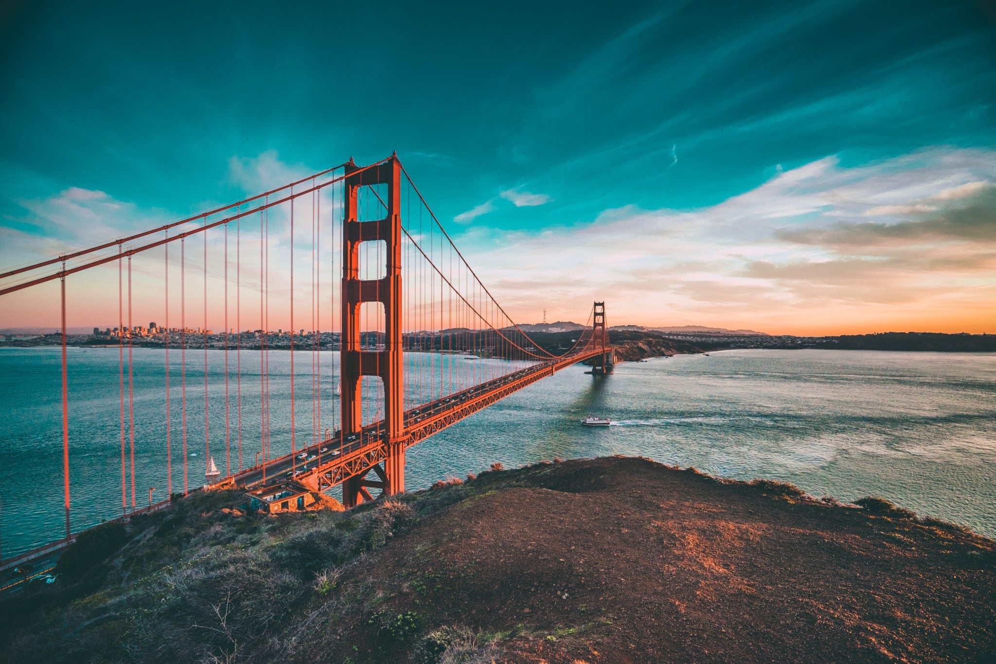 Widok na olbrzymi czerwony most Golden Bridge w San Francisco o zachodzie słońca