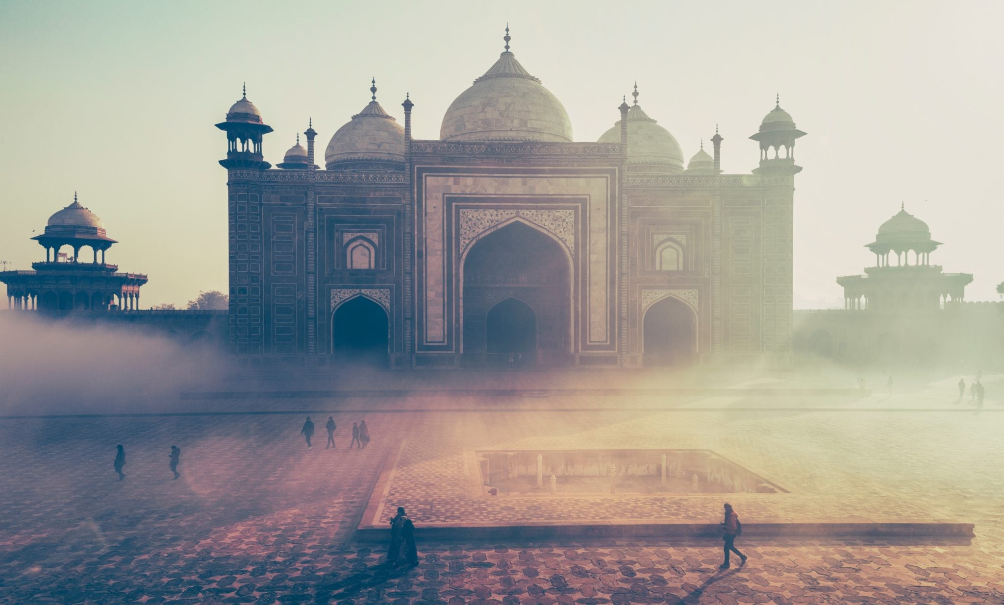 Piękny meczet w mieście Agra w Indiach o wschodzie słońca z ludźmi spacerującymi i podziwiającymi wokół