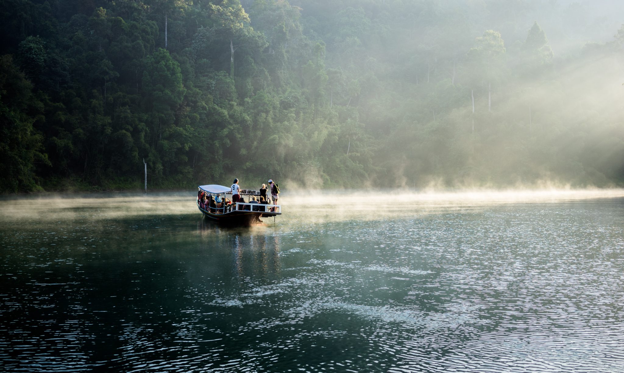 łódka na jeziorze, grupa ludzi na łódce, o wschodzie słońca, mgła, dżungla, ładne światło